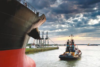 Tugboat assisting cargo ship bow docking Morocco port